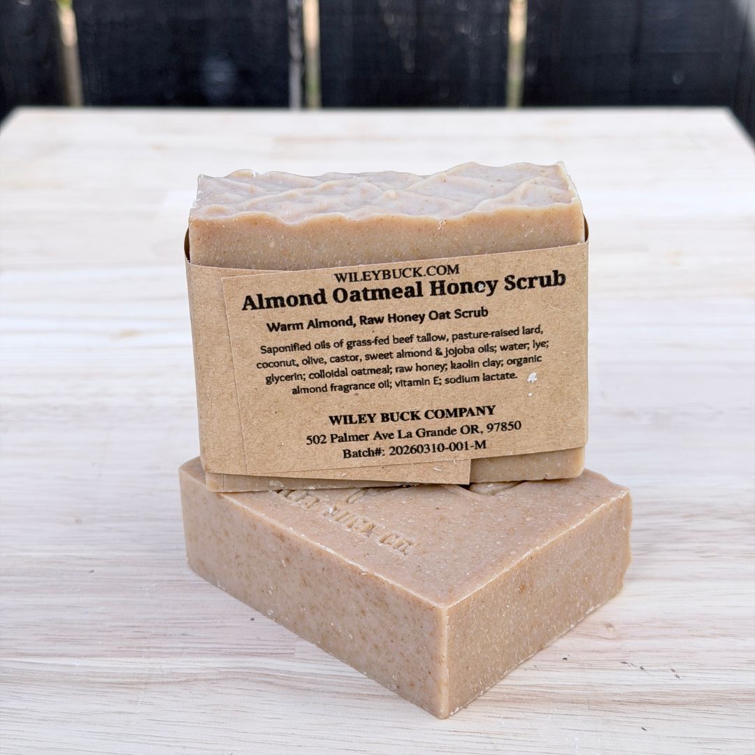 Two bars of Almond Oatmeal Honey Scrub soap stacked on a wooden surface.