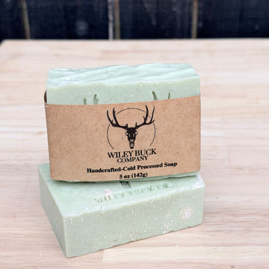 Two bars of soap with a brown label on a wooden surface