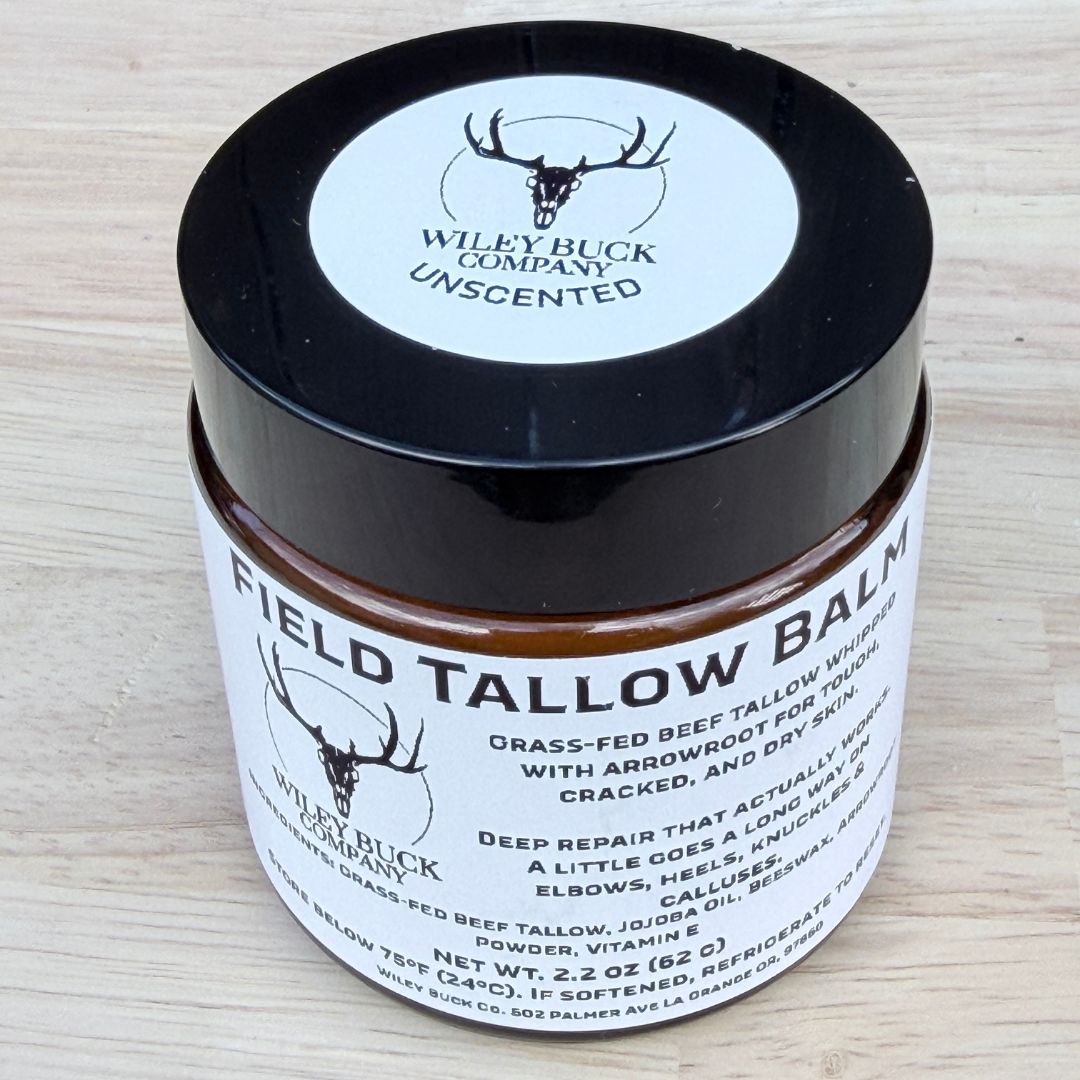 Field Tallow Balm jar with black lid on a light wooden surface