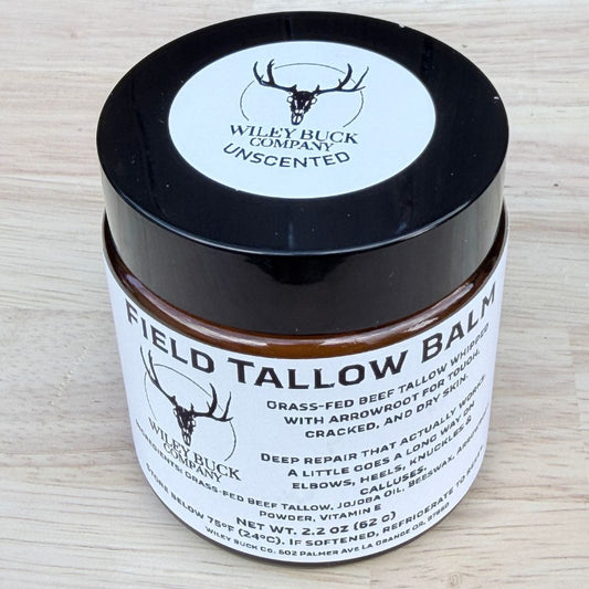 Field Tallow Balm jar with black lid on a light wooden surface
