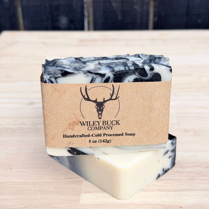 Marble-patterned soap bar with a brown label on a wooden surface