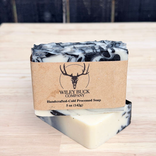 Marble-patterned soap bar with a brown label on a wooden surface