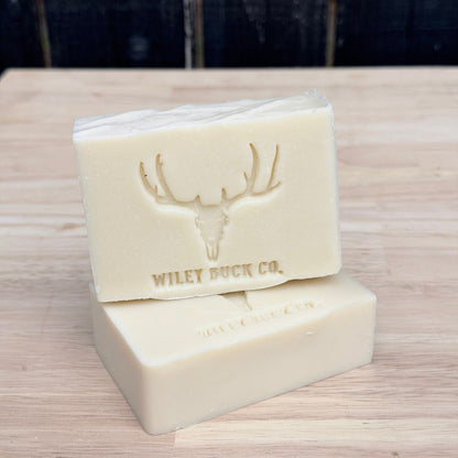 Two bars of soap with a deer emblem and 'Wiley Buck Co.' branding on a wooden surface.