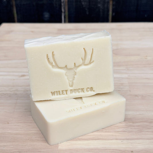 Two bars of soap with a deer emblem and 'Wiley Buck Co.' branding on a wooden surface.