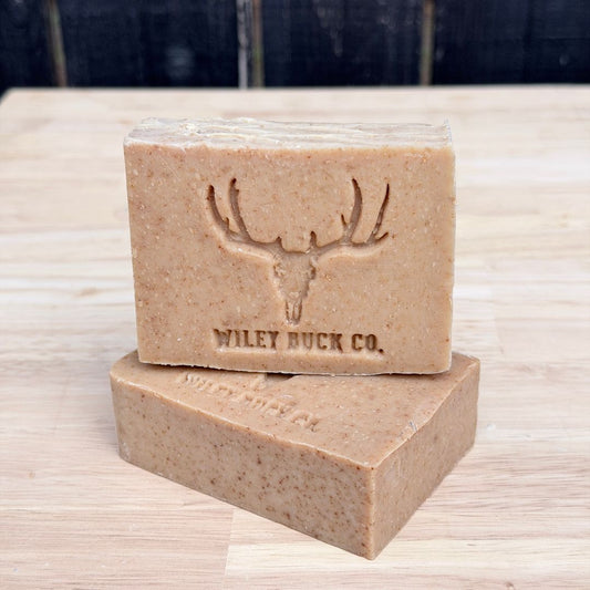 Two bars of soap with a deer emblem and 'Wiley Buck Co.' text on a wooden surface.