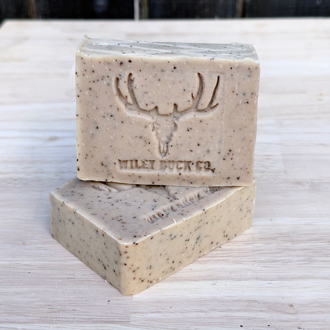 Two bars of soap with a deer emblem and 'Wilde Buck Co.' branding on a light wooden surface.