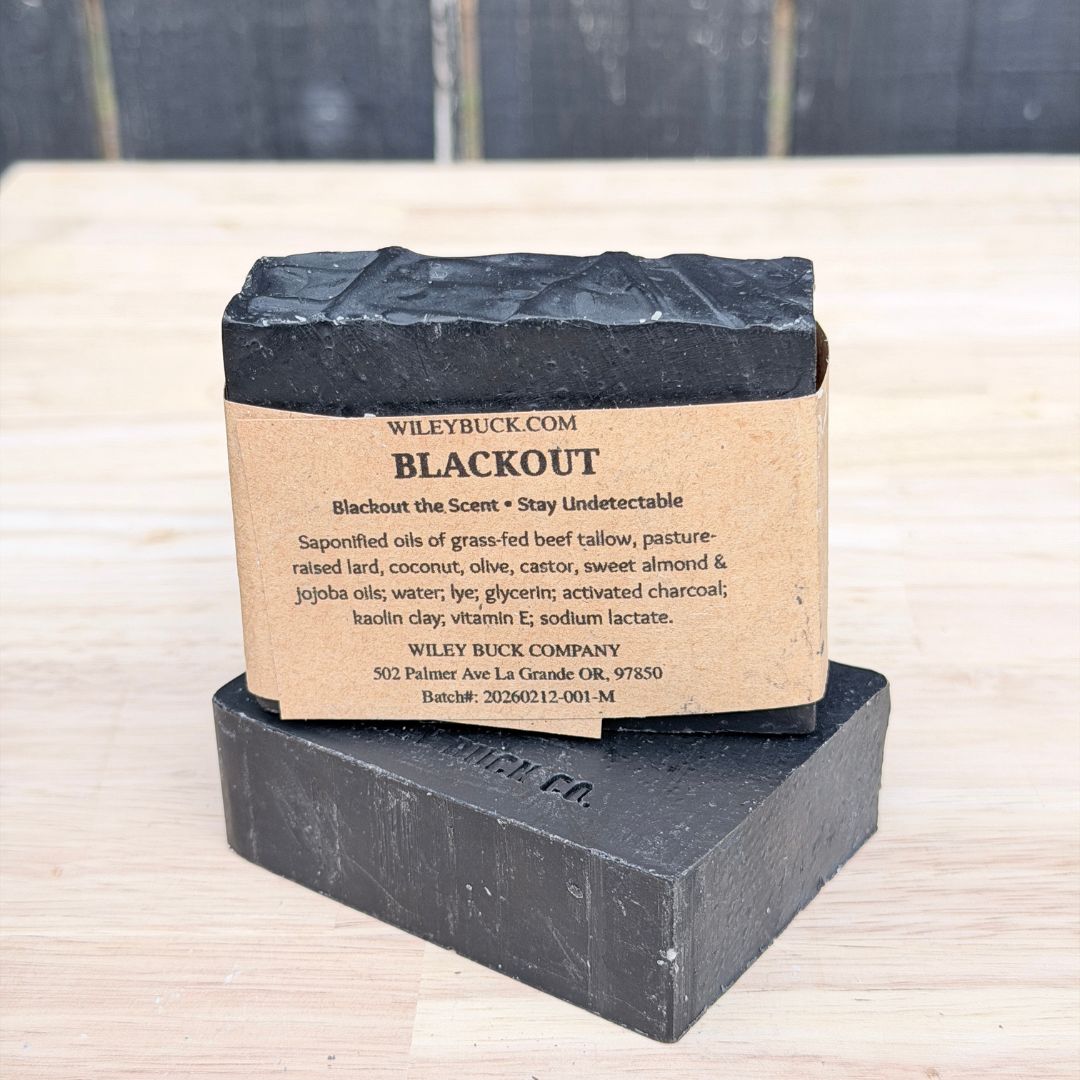 Black soap bar with a cardboard label on a wooden surface