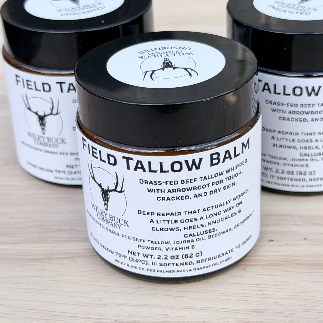 Field Tallow Balm jar with black lid and white label on a wooden surface